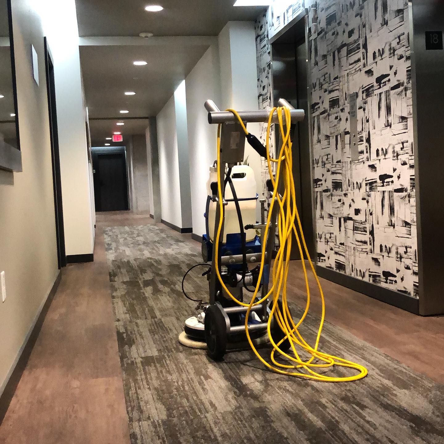 Commercial high-rise corridor with rotary encapsulation cleaning equipment on the 18th floor